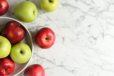 Photo of Ripe red and green apples on white marble table, top view. Space for text