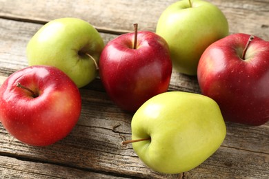 Photo of Ripe red and green apples on wooden table, closeup