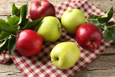 Photo of Ripe apples and green leaves on wooden table