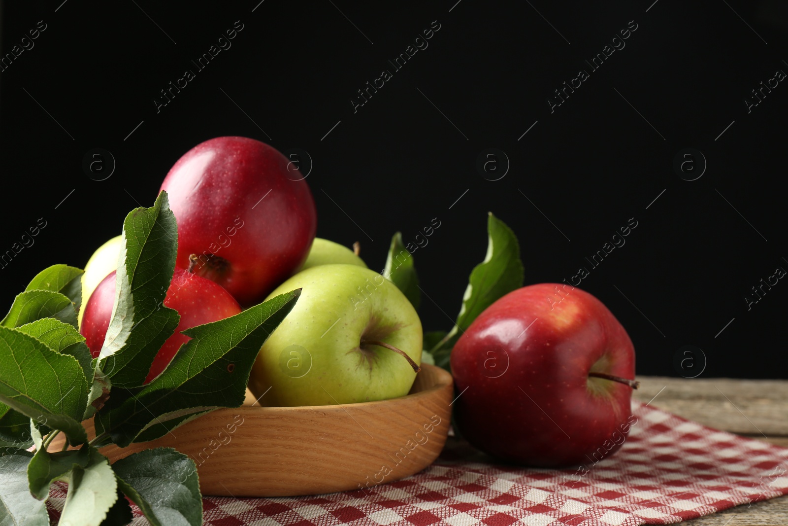 Photo of Ripe apples and green leaves on table