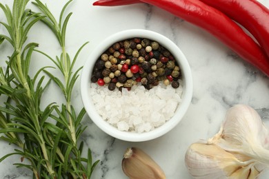 Photo of Sea salt, peppercorns, rosemary, chili peppers and garlic on white marble table, top view