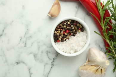 Photo of Sea salt, peppercorns, rosemary, chili peppers and garlic on white marble table, top view. Space for text