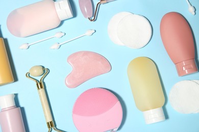 Different skin care products on light blue background, flat lay