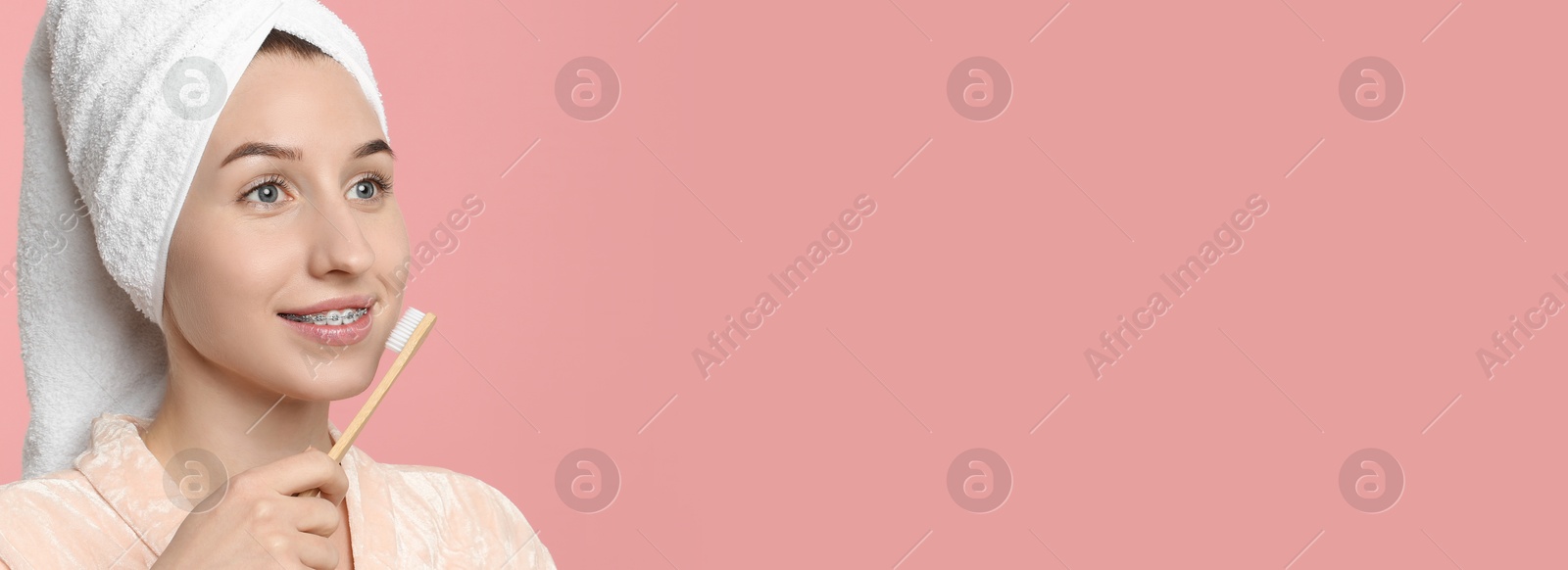 Image of Beautiful woman with braces brushing teeth on pink background. Banner design with space for text