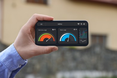 Man monitoring smart meter readings on mobile phone outdoors, closeup