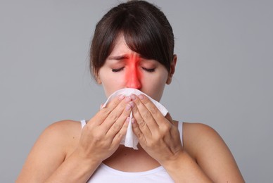 Image of Woman with tissue suffering from sinusitis on grey background