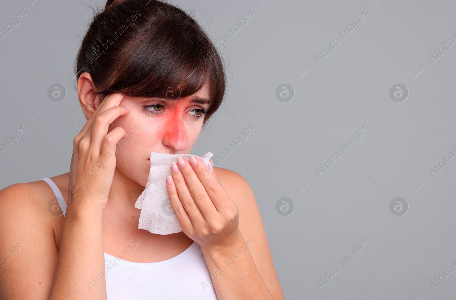 Image of Woman with tissue suffering from sinusitis on grey background. Space for text