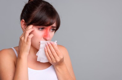 Image of Woman with tissue suffering from sinusitis on grey background. Space for text