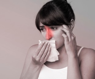 Woman with tissue suffering from sinusitis. Black and white effect with red color accent