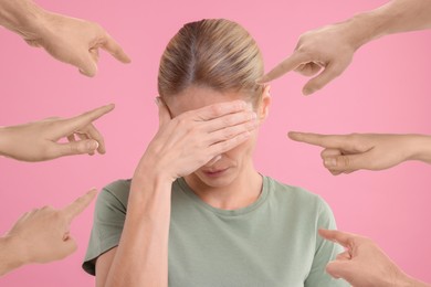 People pointing at embarrassed woman on pink background