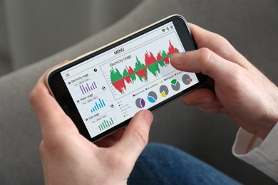 Image of Man monitoring smart meter readings on mobile phone at home, closeup