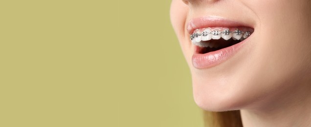 Woman with braces smiling on color background, closeup. Banner design with space for text