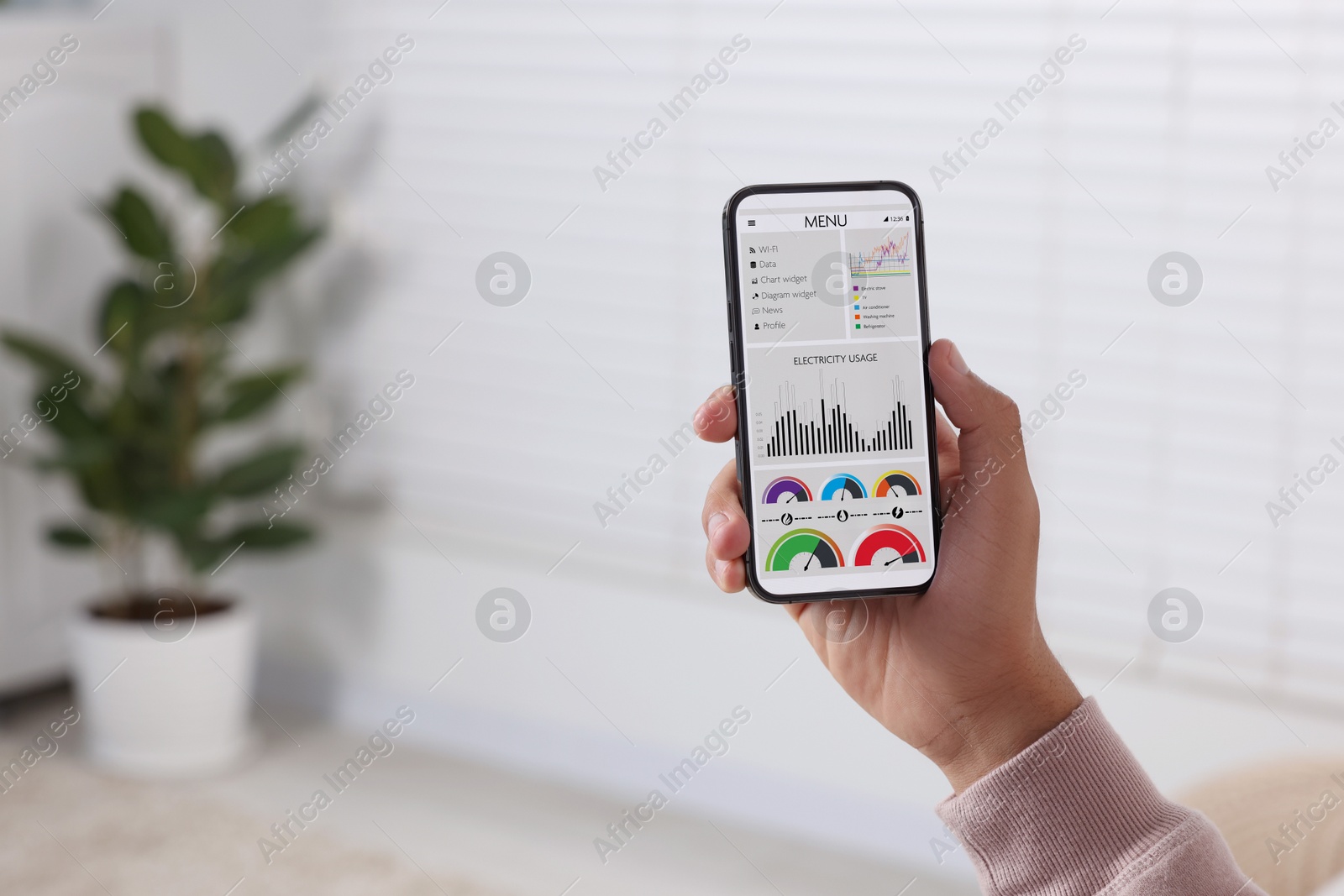 Image of Man monitoring smart meter readings on mobile phone at home, closeup