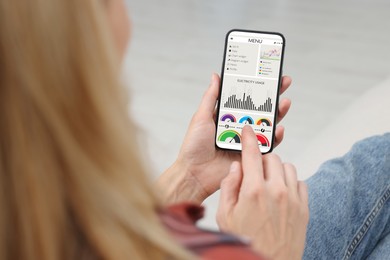 Woman monitoring smart meter readings on mobile phone, closeup