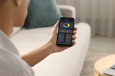 Image of Man monitoring smart meter readings on mobile phone at home, closeup