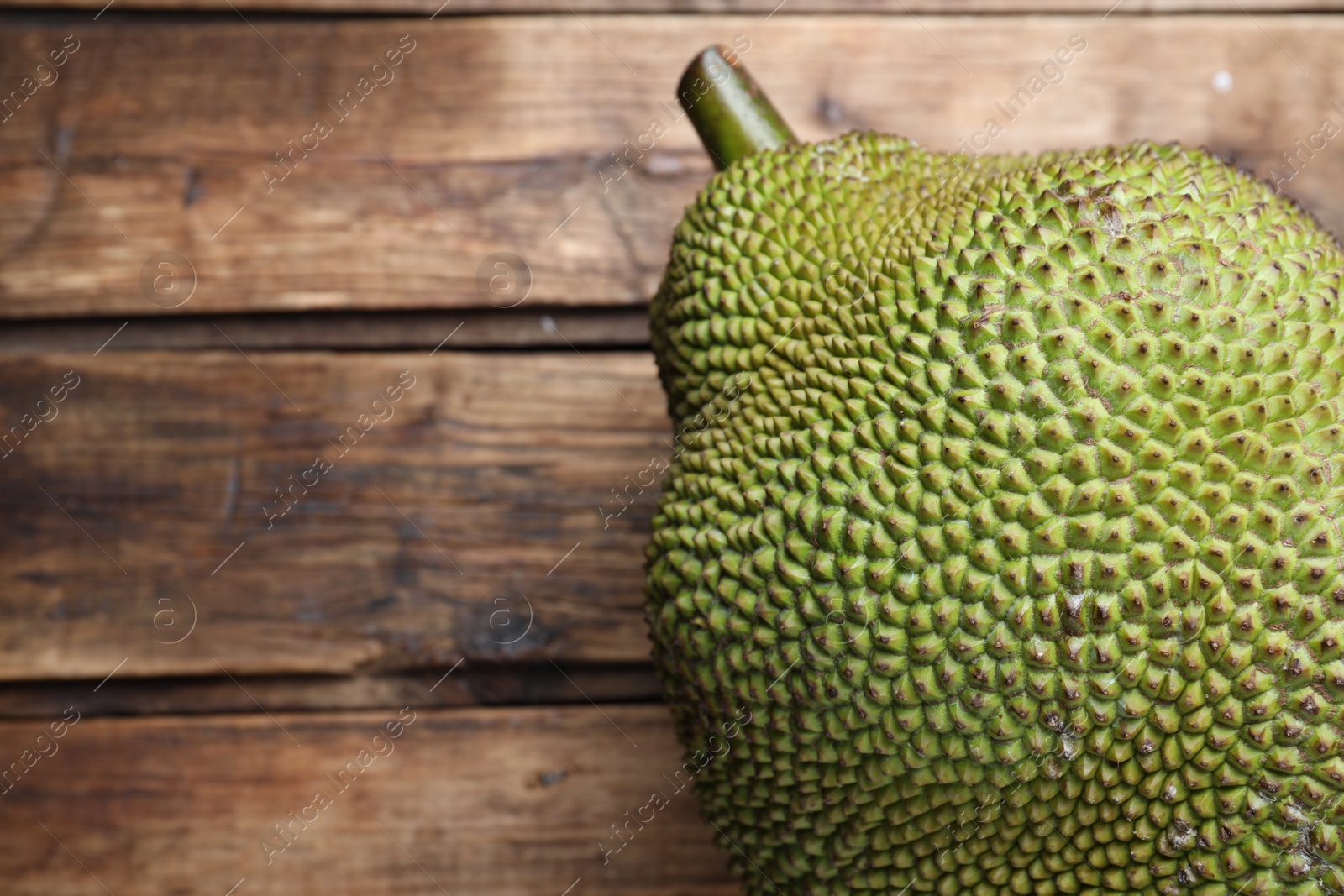 Photo of Fresh exotic jackfruit on wooden table, above view. Space for text