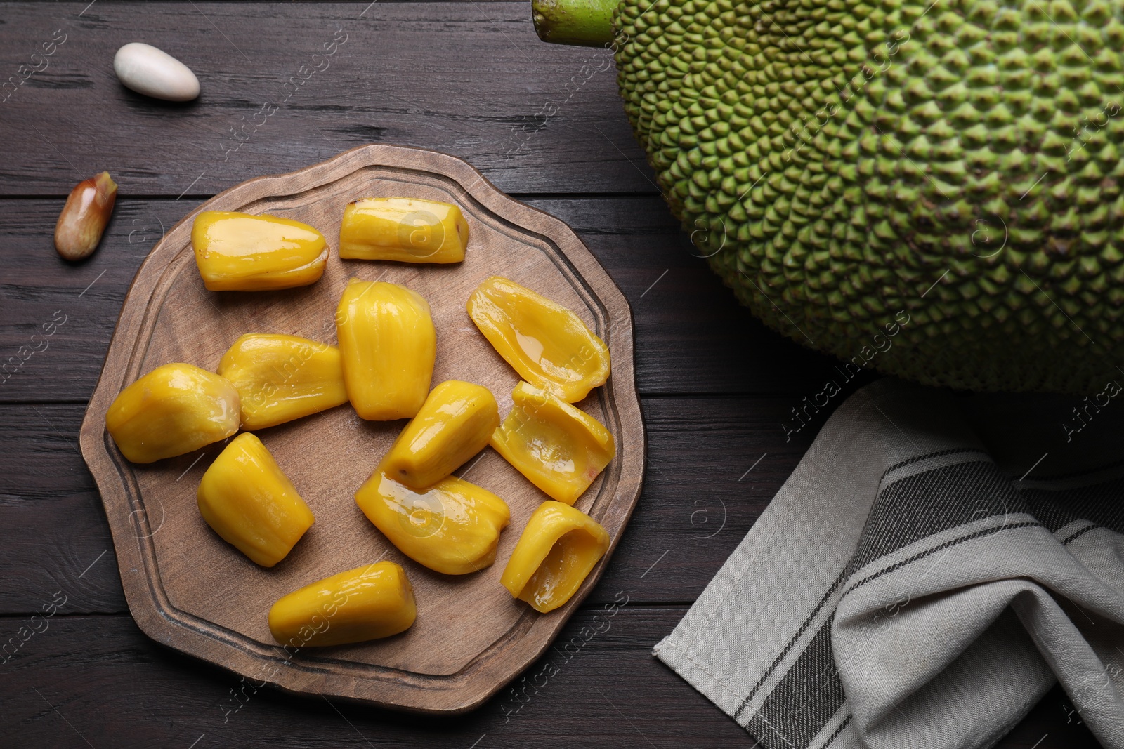 Photo of Fresh exotic jackfruit on black wooden table, flat lay