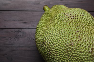 Photo of Fresh exotic jackfruit on black wooden table, above view. Space for text