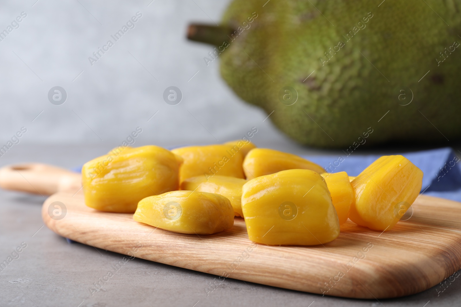 Photo of Delicious exotic jackfruit bulbs on light grey table