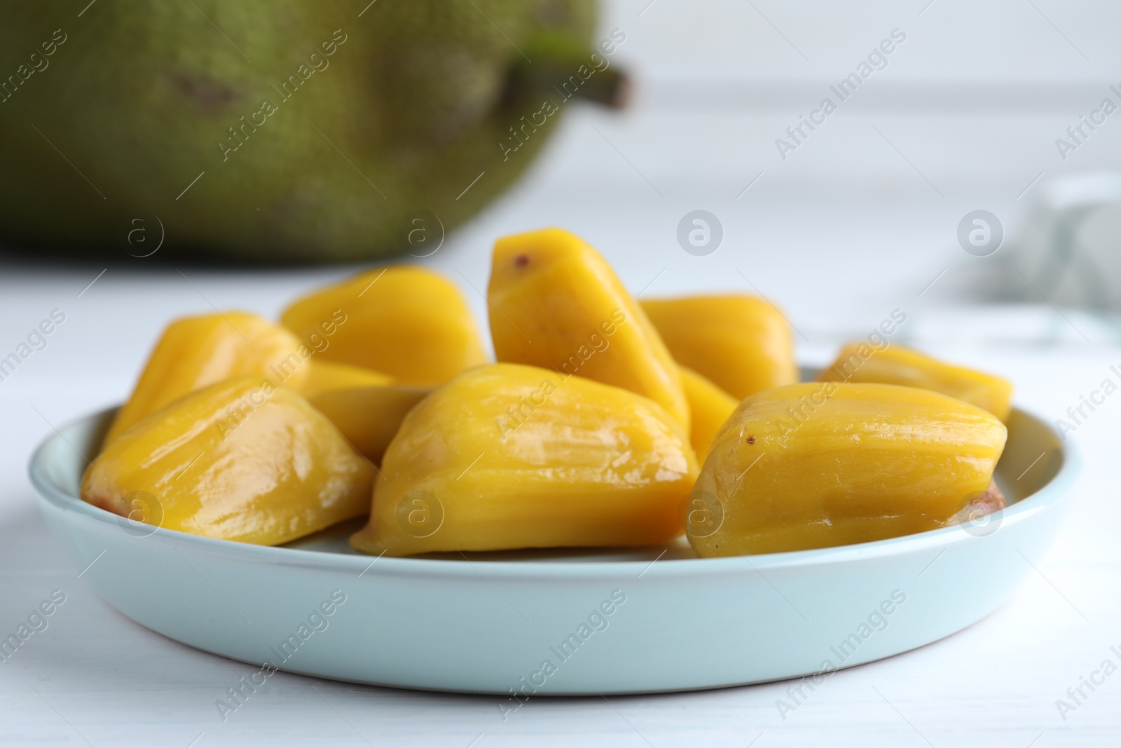 Photo of Delicious exotic jackfruit bulbs on white table, closeup