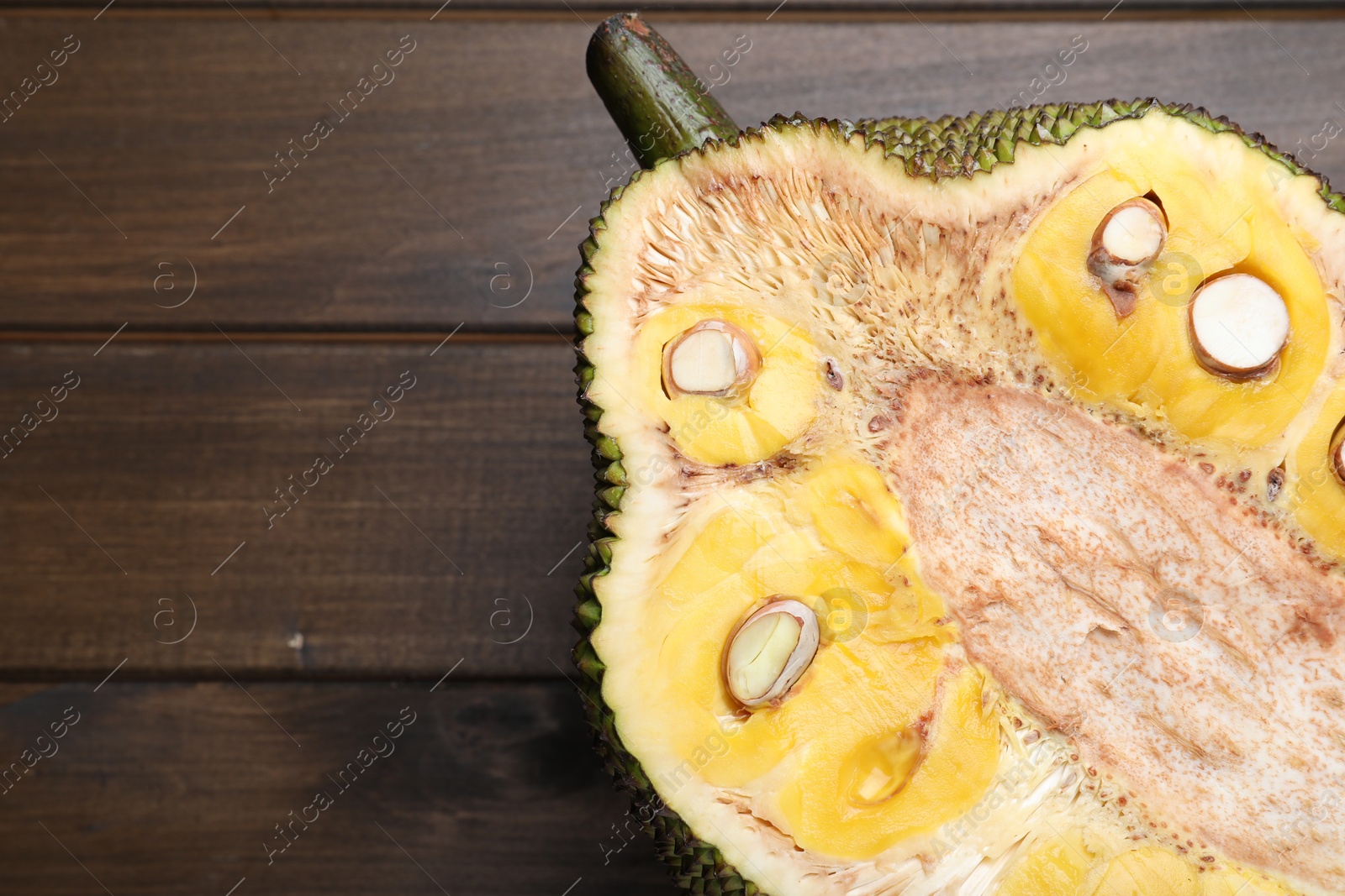 Photo of Half of delicious exotic jackfruit on wooden table, top view. Space for text