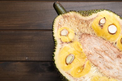 Photo of Half of delicious exotic jackfruit on wooden table, top view. Space for text