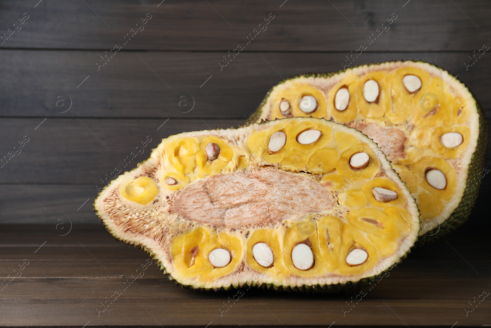 Photo of Delicious cut exotic jackfruit on wooden table