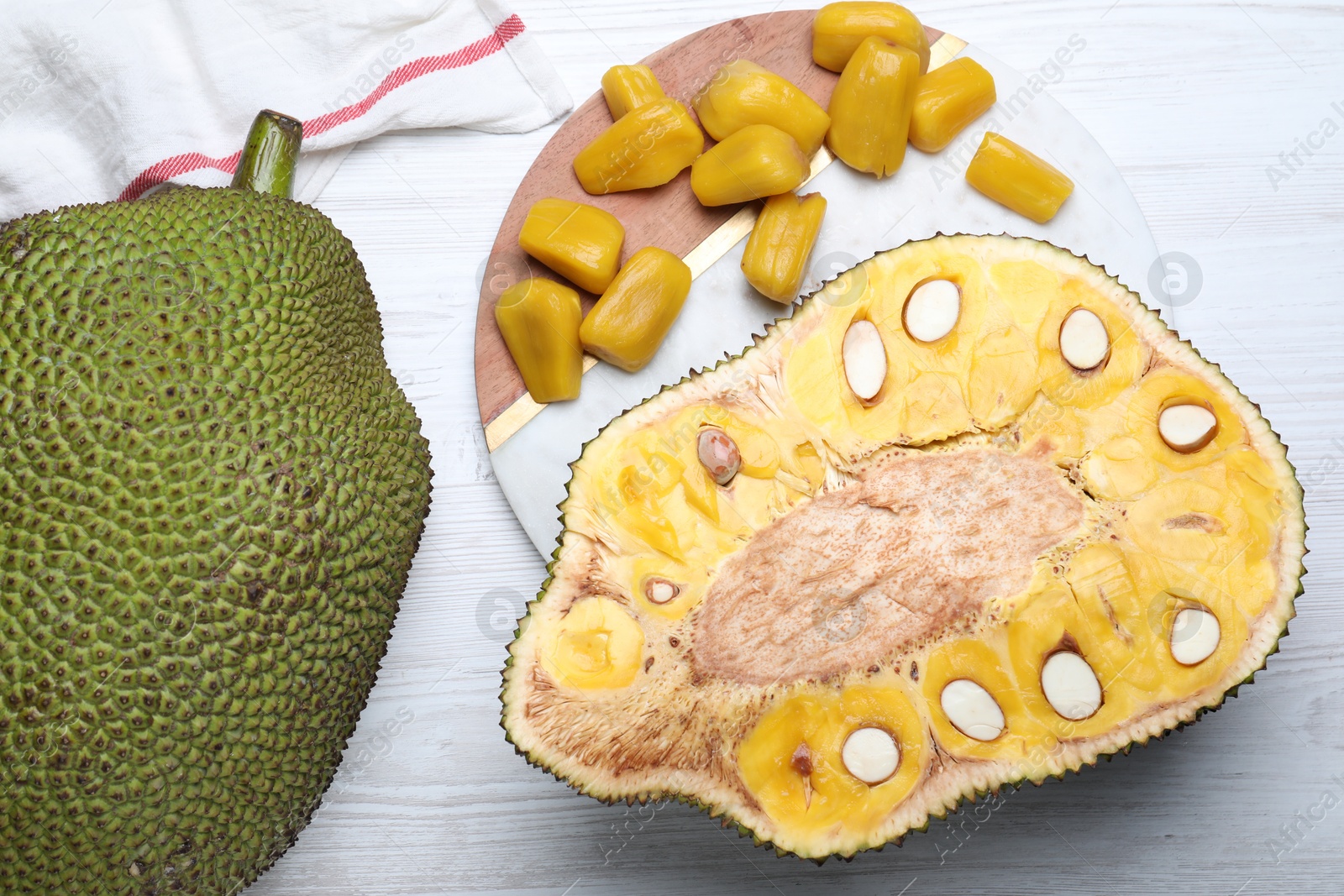 Photo of Delicious exotic jackfruits on white wooden table, flat lay