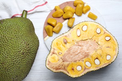 Photo of Delicious exotic jackfruits on white wooden table, flat lay