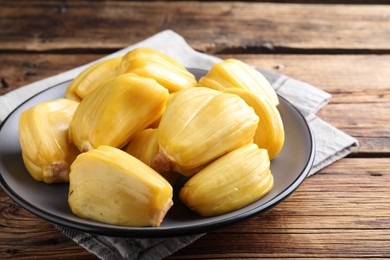 Photo of Delicious exotic jackfruit bulbs on wooden table