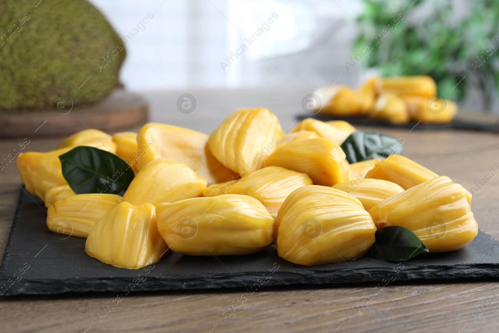 Photo of Fresh exotic jackfruit bulbs on wooden table