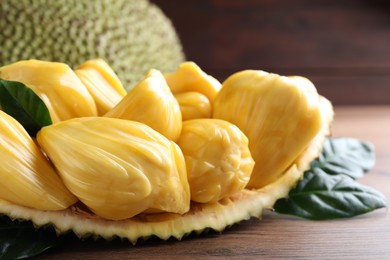 Photo of Fresh exotic jackfruit bulbs on wooden table, closeup