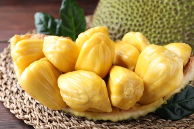 Photo of Fresh exotic jackfruit bulbs on wooden table, closeup