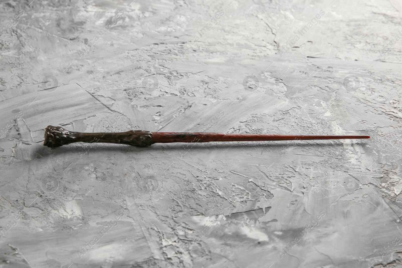 Photo of One magic wand on grey textured table