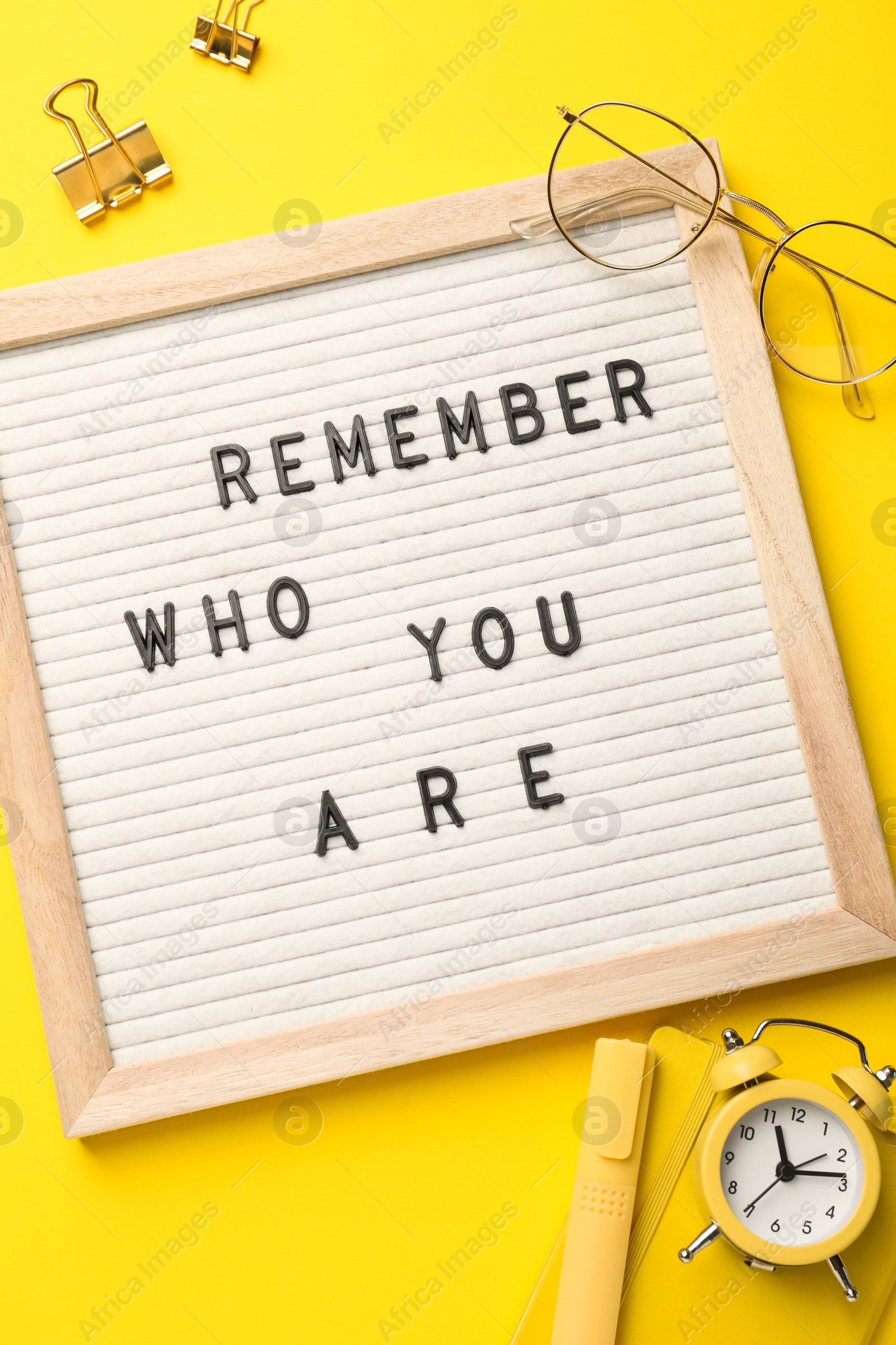 Photo of Flat lay composition of letter board with phrase Remember Who You Are on yellow background