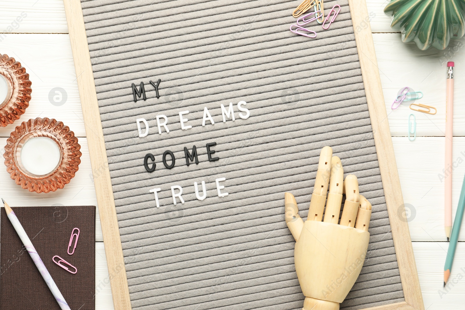 Photo of Flat lay composition of letter board with phrase My Dreams Come True on white wooden table