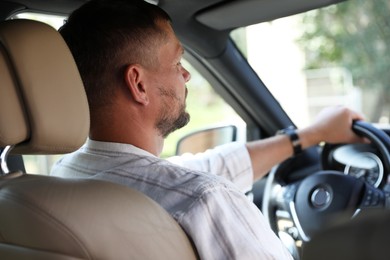 Man holding steering wheel while driving car