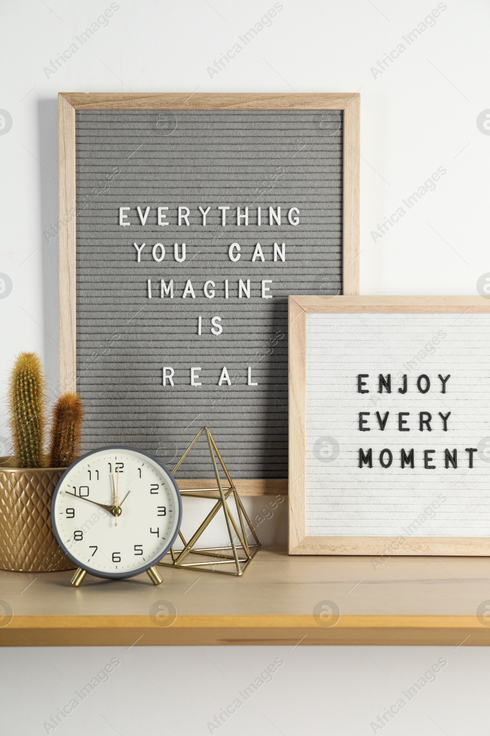 Photo of Letter boards with phrases Everything You Can Imagine Is Real, Enjoy Every moment and decor elements on wooden table