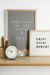 Photo of Letter boards with phrases Everything You Can Imagine Is Real, Enjoy Every moment and decor elements on wooden table