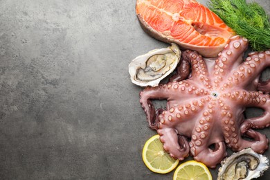 Different sea food on grey table, flat lay. Space for text