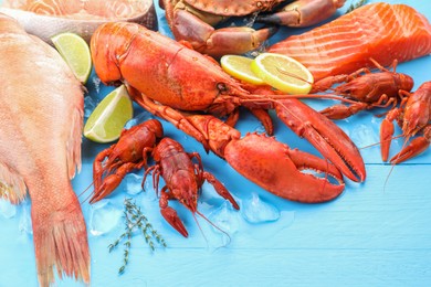 Different sea food on light blue wooden table, closeup