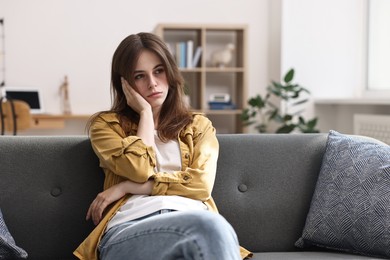 Loneliness concept. Sad teenage girl on sofa at home