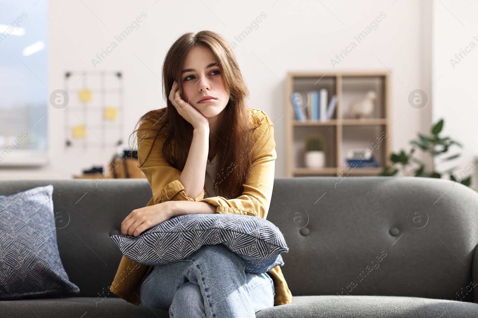 Photo of Loneliness concept. Sad teenage girl with pillow on sofa at home