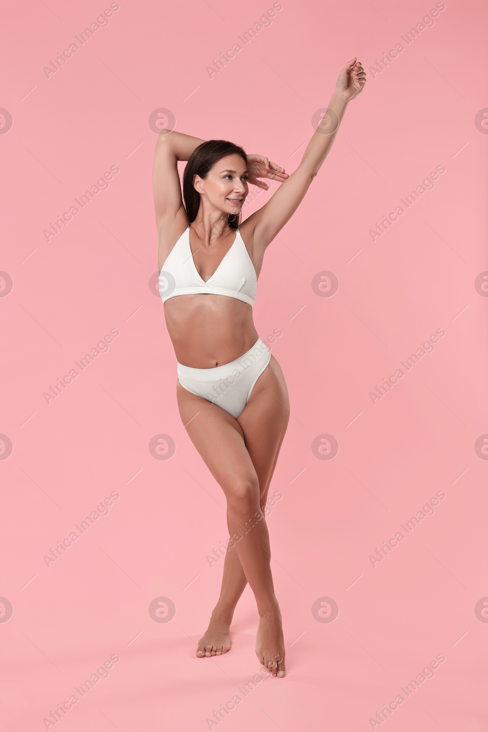 Photo of Smiling woman with perfect skin on pink background. Body care