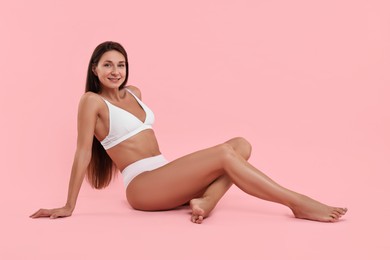 Photo of Smiling woman with perfect skin posing on pink background. Body care