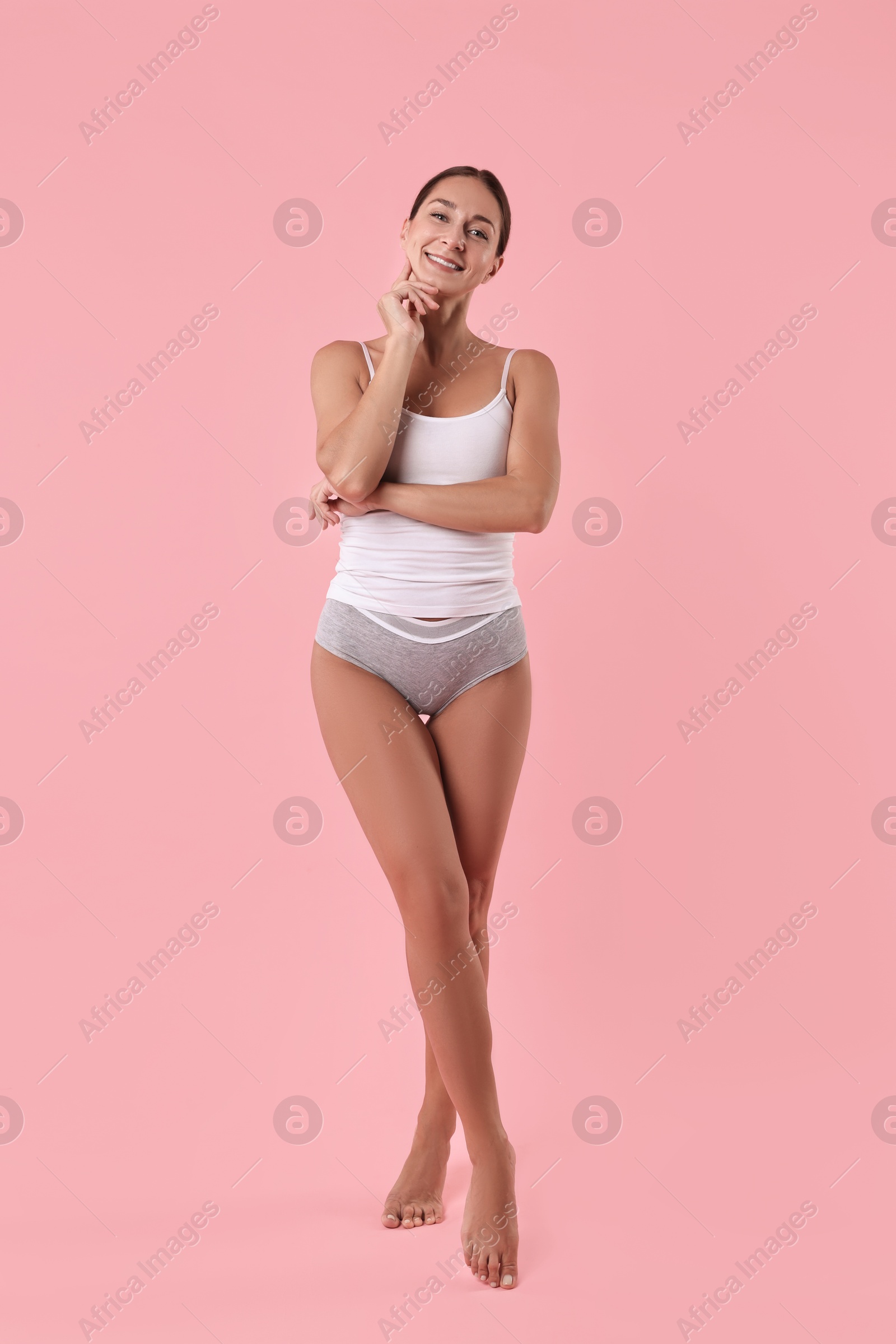 Photo of Smiling woman with perfect skin on pink background. Body care