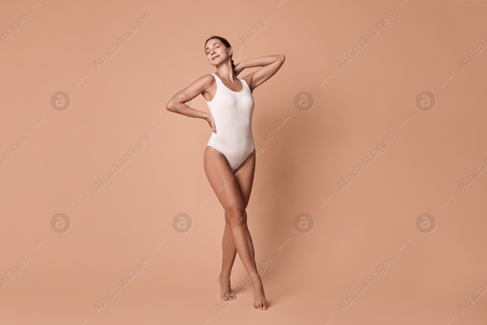 Photo of Beautiful woman with perfect skin posing on beige background. Body care