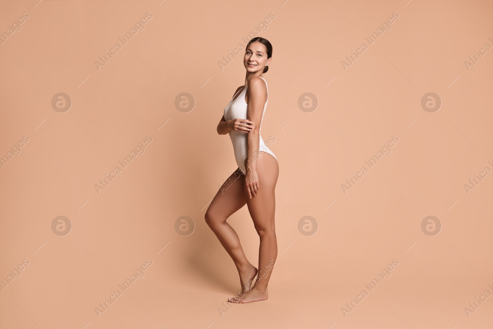 Photo of Smiling woman with perfect skin on beige background. Body care