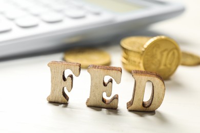 Photo of Wooden letters Fed (Federal Reserve System) on white table, closeup