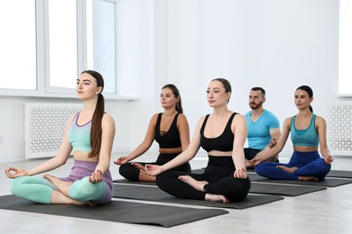 Group of people meditating on mats in yoga class